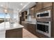 Kitchen showcasing stainless steel KitchenAid appliances, wood cabinets with gold hardware, and white countertop island sink at 14265 Currant St, Broomfield, CO 80020