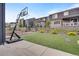 Backyard with artificial turf, fenced perimeter, a basketball hoop, and multi-story homes in the background at 9836 Banner Peak St, Littleton, CO 80125