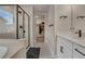 Well lit bathroom with walk in shower, quartz countertops, double vanity sinks, and a walk in closet at 9836 Banner Peak St, Littleton, CO 80125