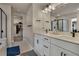 Modern bathroom with double vanity, white cabinets, black hardware, a glass-enclosed shower, and a walk-in closet at 9836 Banner Peak St, Littleton, CO 80125