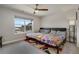 Bedroom with a large window and ceiling fan features two beds and a colorful rug at 9836 Banner Peak St, Littleton, CO 80125