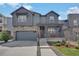 Charming two-story home with stone accents, a covered porch, a gray exterior, and a well-manicured lawn at 9836 Banner Peak St, Littleton, CO 80125