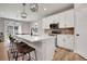 Open-concept kitchen with white cabinets, stainless steel appliances, and a large center island with bar seating at 9836 Banner Peak St, Littleton, CO 80125