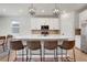 Spacious kitchen featuring white cabinets, stainless steel appliances, a large island, and modern pendant lighting at 9836 Banner Peak St, Littleton, CO 80125