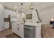 Bright kitchen with a center island, stainless steel appliances, white cabinets, and hardwood flooring at 9836 Banner Peak St, Littleton, CO 80125
