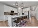 Bright kitchen with white cabinets, stainless steel appliances, a center island with seating, and modern lighting at 9836 Banner Peak St, Littleton, CO 80125