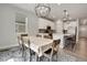 Open-concept kitchen with a dining area, featuring white cabinets, stainless steel appliances, and modern lighting at 9836 Banner Peak St, Littleton, CO 80125