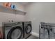 Laundry room area with modern washer and dryer set and shelving at 9836 Banner Peak St, Littleton, CO 80125