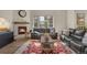 Comfortable living area with fireplace, couches, and a large window, perfect for relaxing and entertaining at 9836 Banner Peak St, Littleton, CO 80125