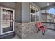 Inviting front porch with stone accents, gray siding, and cozy seating for enjoying the outdoors at 9836 Banner Peak St, Littleton, CO 80125