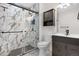 Modern bathroom featuring a tiled shower with glass door and a sleek vanity at 873 Mockingbird St, Brighton, CO 80601