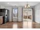 Dining area with wood floors, an elegant light fixture, a sliding glass door to a deck, and stainless fridge at 873 Mockingbird St, Brighton, CO 80601