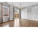 Bright dining area with wood floors, a modern light fixture, and sliding glass doors leading to an outdoor space at 873 Mockingbird St, Brighton, CO 80601