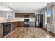 Kitchen featuring wood floors, modern appliances, stainless steel refrigerator, and tile backsplash at 873 Mockingbird St, Brighton, CO 80601