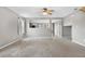 Open living room with neutral carpet, gray walls, and a passthrough to the kitchen, showing ample light at 873 Mockingbird St, Brighton, CO 80601