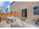 Relaxing deck area with a glass table, chairs, and a sliding glass door to home at 873 Mockingbird St, Brighton, CO 80601