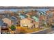 A view of the rear exterior of several multi-story townhomes facing a lake, each with private yards at 873 Mockingbird St, Brighton, CO 80601