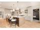 Spacious kitchen island with seating, stainless appliances, light cabinets, and open design with access to hall at 2610 N Monroe St, Denver, CO 80205