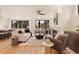Cozy living room with fireplace, hardwood floors, modern furnishings, and seamless flow to kitchen area at 2610 N Monroe St, Denver, CO 80205