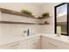 Pantry area with floating wood shelves, stylish decor, and white cabinets featuring brass hardware at 2610 N Monroe St, Denver, CO 80205