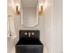 Chic powder room with unique fixtures including a black sink, modern lighting, and elegant towel rack at 2610 N Monroe St, Denver, CO 80205