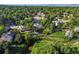 Aerial view shows homes in a lush neighborhood with mature trees and a tranquil stream at 9465 W 77Th Dr, Arvada, CO 80005