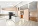 Well-lit kitchen with white cabinets, kitchen island with cooktop, and access to the living area at 9465 W 77Th Dr, Arvada, CO 80005