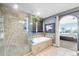 Bathroom featuring a bathtub, a shower with glass door, and gray walls at 19080 E Low Cir, Aurora, CO 80015