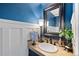 Powder room featuring blue walls, a decorative mirror, and a stone countertop at 19080 E Low Cir, Aurora, CO 80015