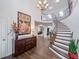 Grand foyer featuring a curved staircase, hardwood floors, elegant chandelier, and a decorative console table at 19080 E Low Cir, Aurora, CO 80015