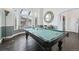 Bright game room featuring a large pool table, hardwood floors, and plenty of natural light from the large window at 19080 E Low Cir, Aurora, CO 80015