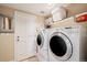 Laundry room featuring stacked washer and dryer, and overhead shelving for storage at 19080 E Low Cir, Aurora, CO 80015