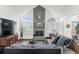 Bright living room with high ceilings, a fireplace, large windows with shutters, and comfortable leather furniture at 19080 E Low Cir, Aurora, CO 80015
