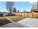 Fenced backyard with grass, a concrete patio, and an adjacent modern house at 4729 N Meade St, Denver, CO 80211