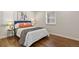 Comfortable bedroom with hardwood floors, large window, and stylish blue headboard at 4729 N Meade St, Denver, CO 80211