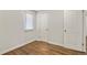 Empty bedroom with hardwood floors, one window, neutral walls and two doors at 4729 N Meade St, Denver, CO 80211