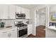 Modern kitchen features white cabinets, stainless steel appliances, and mosaic backsplash at 4729 N Meade St, Denver, CO 80211