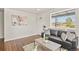 Well-lit living room featuring a comfortable sofa and large window with a view at 4729 N Meade St, Denver, CO 80211