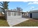 A gray house exterior with a sunroom, concrete patio, and detached garage at 4729 N Meade St, Denver, CO 80211