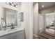 Bright bathroom featuring a vanity with white cabinets, a decorative mirror, and tile flooring at 17748 W 95Th Ave, Arvada, CO 80007