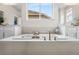 Modern bathroom featuring a soaking tub with elegant fixtures and bright natural light at 17748 W 95Th Ave, Arvada, CO 80007
