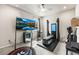 Fully equipped home gym with exercise equipment and a large screen television for entertainment at 17748 W 95Th Ave, Arvada, CO 80007