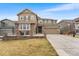 Attractive two-story home with a three-car garage, well-maintained lawn and stone accents on the facade at 17748 W 95Th Ave, Arvada, CO 80007