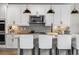 Modern kitchen with white cabinets, stainless steel appliances, stylish pendant lighting, and a granite countertop island at 17748 W 95Th Ave, Arvada, CO 80007
