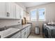 Well-lit laundry room with ample cabinet space, modern appliances, and a convenient sink at 17748 W 95Th Ave, Arvada, CO 80007