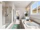 Spacious bathroom featuring a soaking tub and a glass shower showcasing a tranquil view into the bedroom at 17748 W 95Th Ave, Arvada, CO 80007