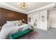 A sophisticated main bedroom is showcased with a wood accent wall and elegant chandelier lighting at 17748 W 95Th Ave, Arvada, CO 80007
