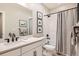 Stylish bathroom features a shower with patterned curtain, white vanity, and modern fixtures at 6255 Kenzie Cir, Castle Pines, CO 80108