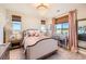 Cozy bedroom with a chandelier, two windows with bamboo shades, and a desk at 6255 Kenzie Cir, Castle Pines, CO 80108