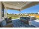 Relaxing covered patio with comfortable seating and views of the fenced backyard at 6255 Kenzie Cir, Castle Pines, CO 80108